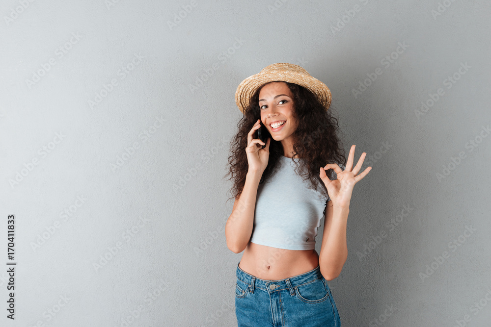 Cute cheerful lady in hat talking on smartphone Cute cheerful lady in hat talking on smartphone