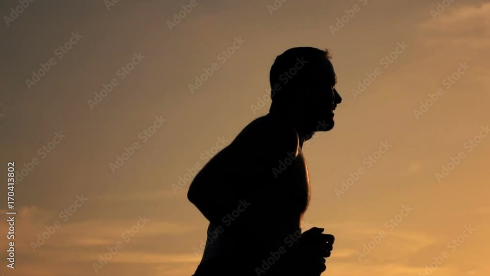 Silhouette of man jogging during sunset, super slow motion 240fps
Silhouette of man jogging during sunset, super slow motion 240fps