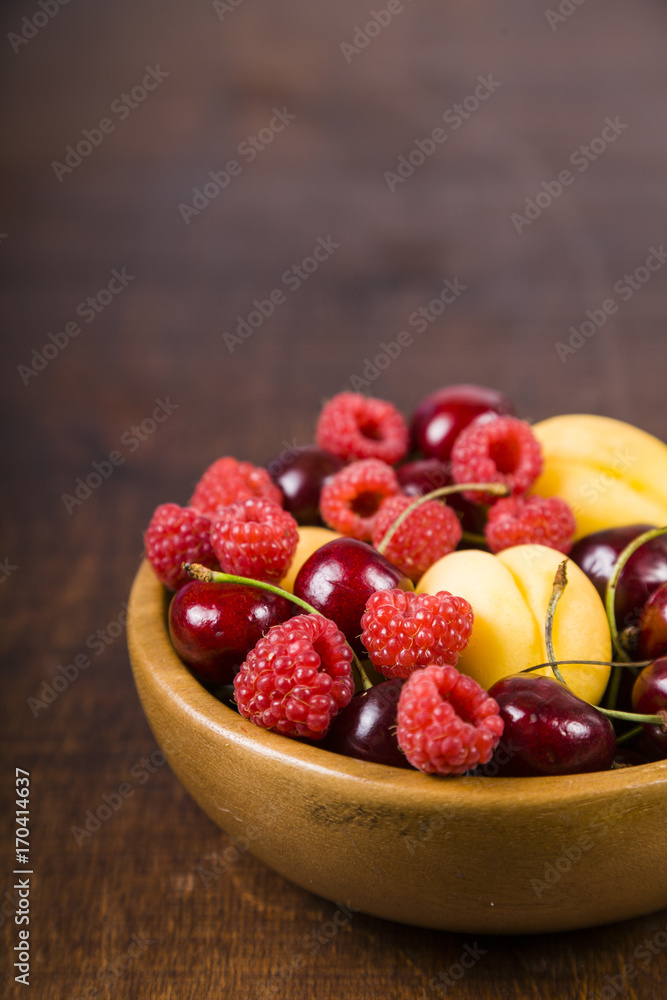 Ripe berries in a plate on a wooden table. Ripe berries in a plate on a wooden table.