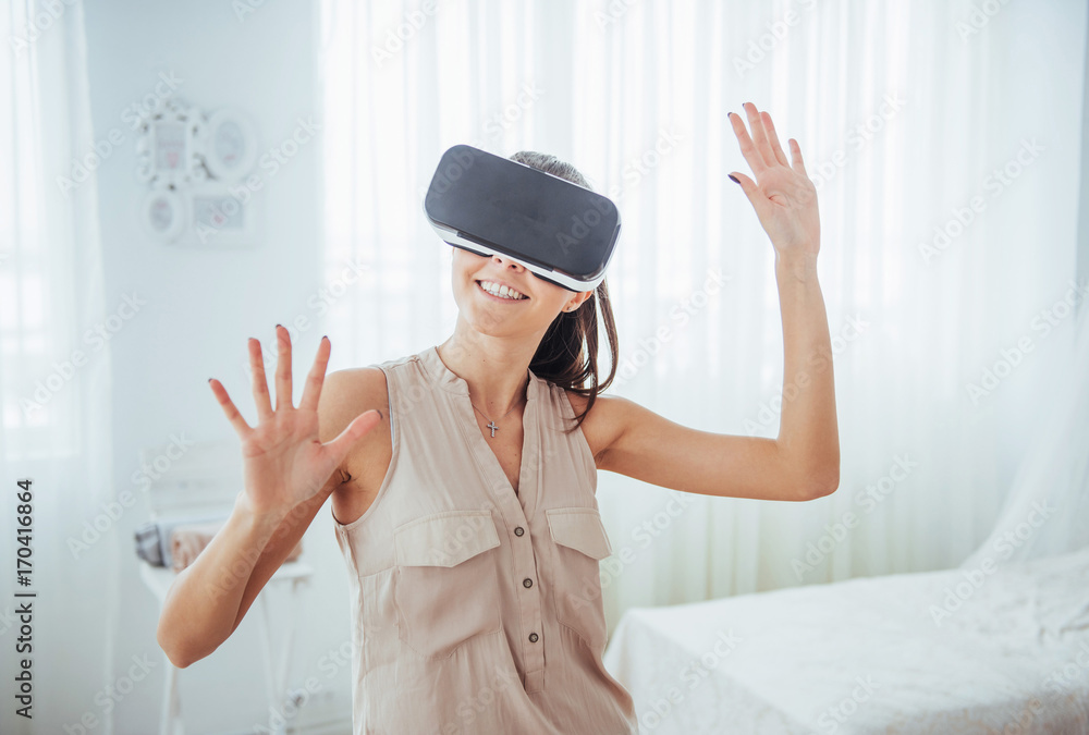 Happy woman gets experience of using VR-glasses virtual reality headset in a bright studio Happy woman gets experience of using VR-glasses virtual reality headset in a bright studio