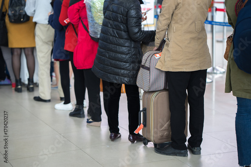 Queue of Asian people waiting at boarding gate at airport. Closeup.