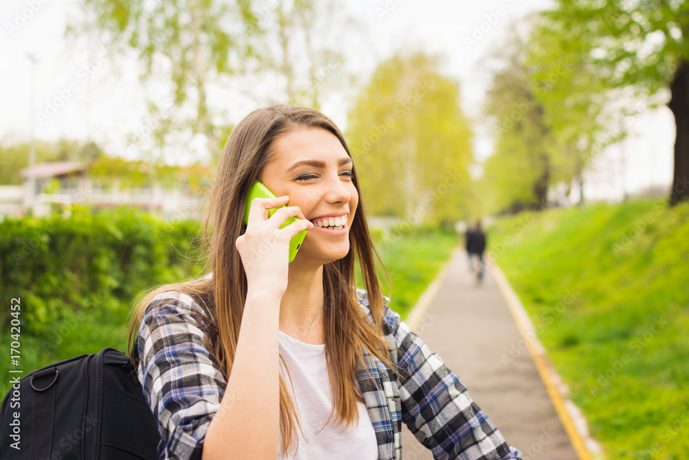 Happy teenage student girl talking on the phone outdoors Happy teenage student girl talking on the phone outdoors