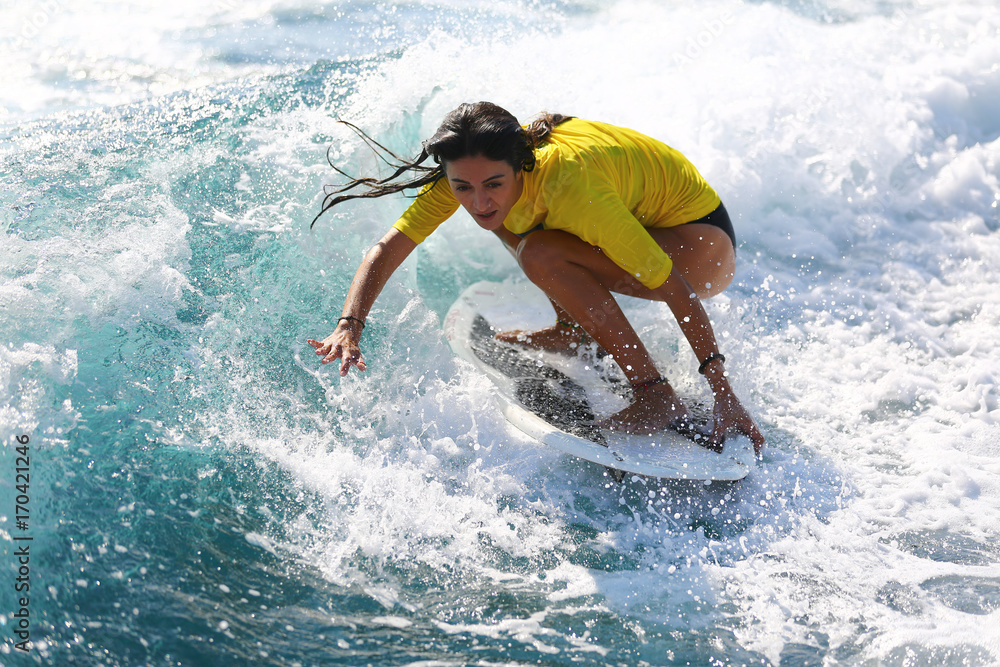 Young girl surfing on the waves.