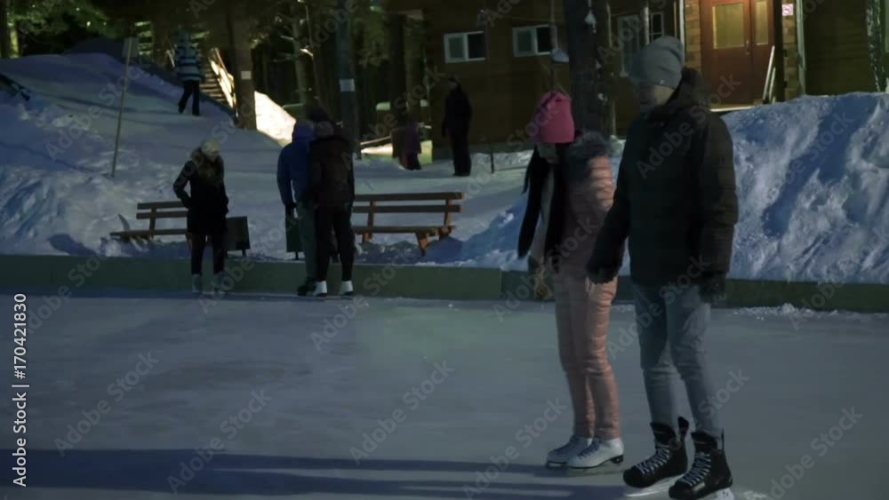Young couple rolling on the ice and raising their hands slow motion Young couple rolling on the ice and raising their hands slow motion