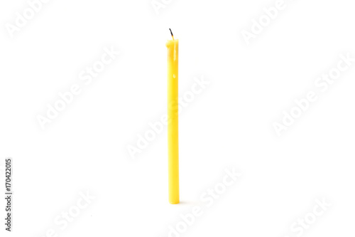 Tall yellow wax candle on a white background.