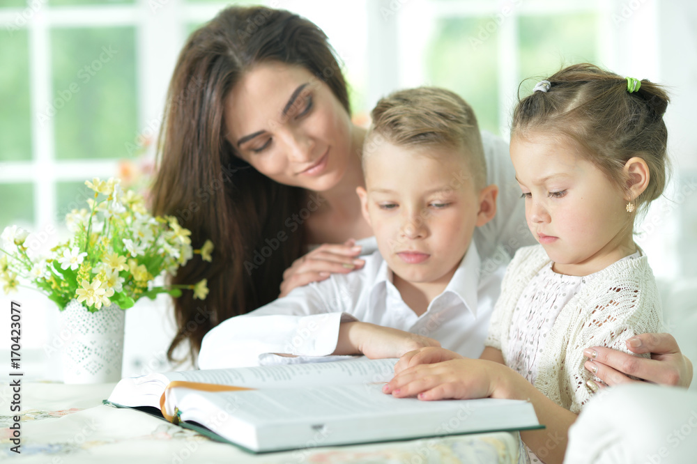 Mother and children reading book