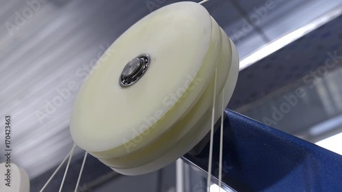 Production of cable products. Rollers a tension of a ready cable before winding on the coil.