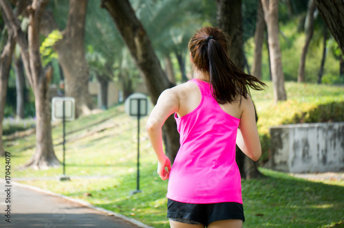 Asian sport woman running / jogging in park for health