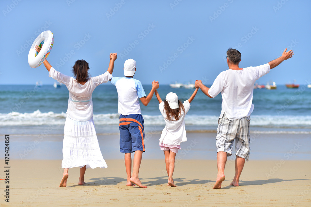 family standing on sandy beach family standing on sandy beach