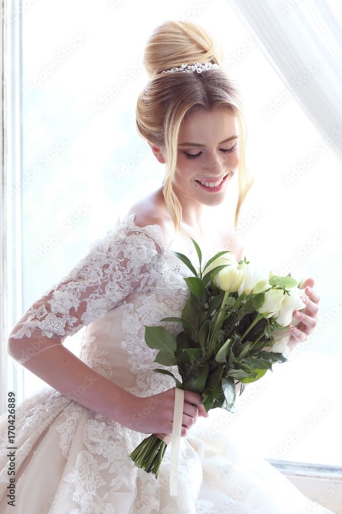Young beautiful bride. Wedding hairstyle, blond hair, wedding dress, makeup and bride's bouquet. Young beautiful bride. Wedding hairstyle, blond hair, wedding dress, makeup and bride's bouquet.