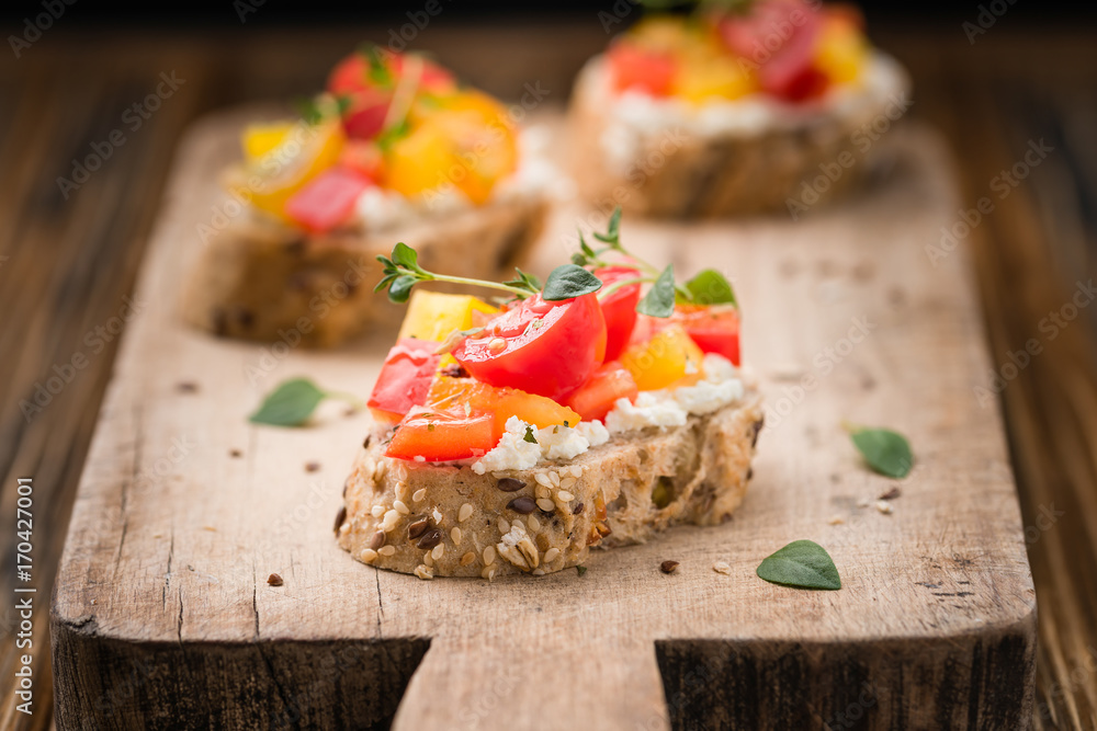 Φωτογραφία Traditional Italian appetizer, bruschetta with cottage cheese, cherry tomatoes, pepper, olives and fresh thyme