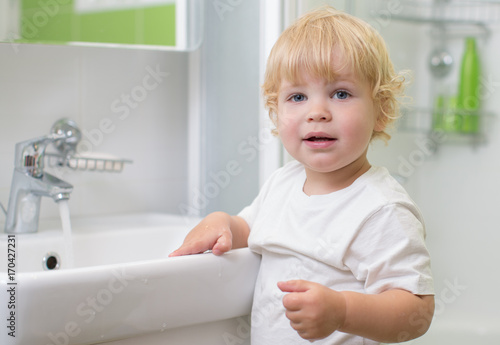 kid washing hands in bathroom