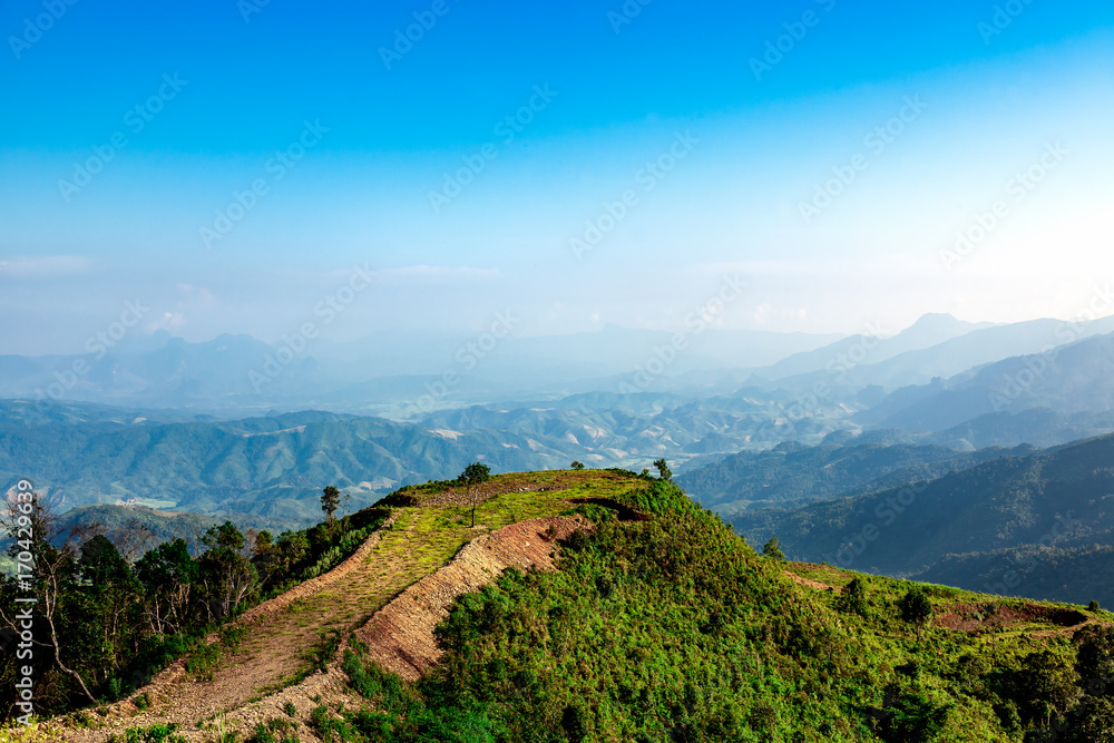 Obraz premium A landscape of green hills with Blue mountains and valley 