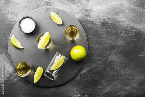 Tequila with lime and salt on a dark background. Top view, copy space. Food background