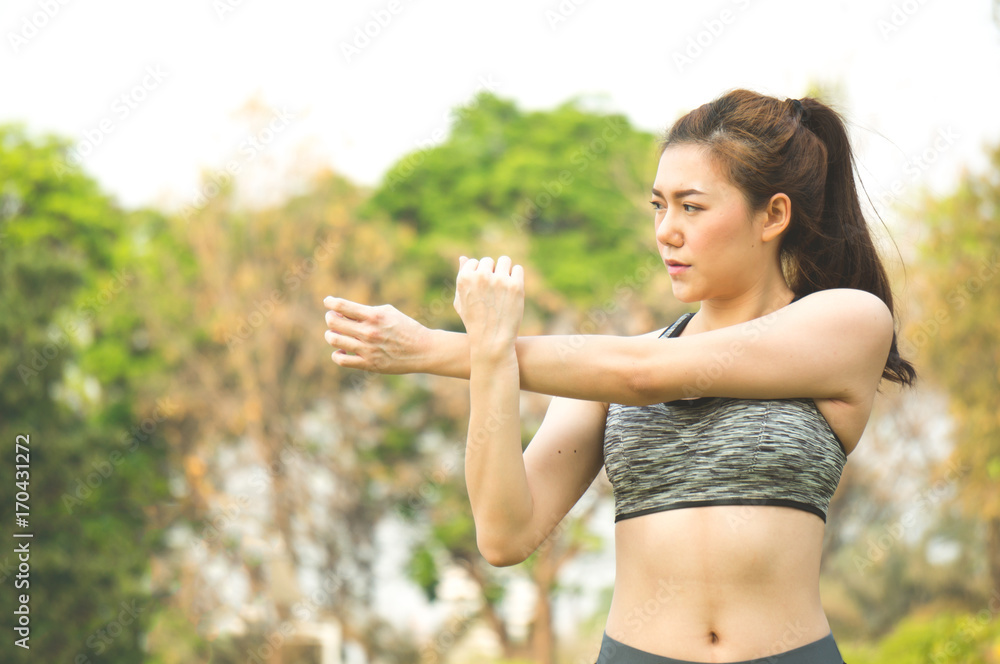Asian sport woman warm up to exercise in park outdoor on green tree background for health Asian sport woman warm up to exercise in park outdoor on green tree background for health