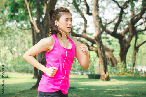 Asian sport woman running / jogging in park for health