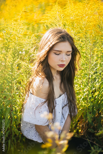 Young girl in a field of yellow flowers