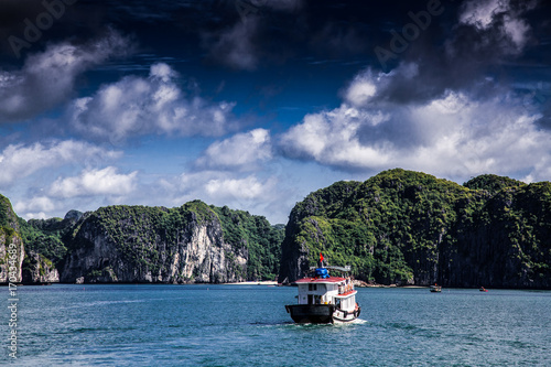 cruising among beautiful limestone rocks and secluded beaches in Ha Long bay, UNESCO world heritage site, Vietnam