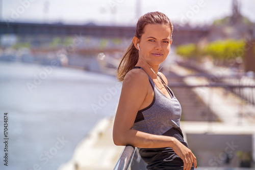 Sporty woman listening music before running. Female athlete listening music while doing sport.