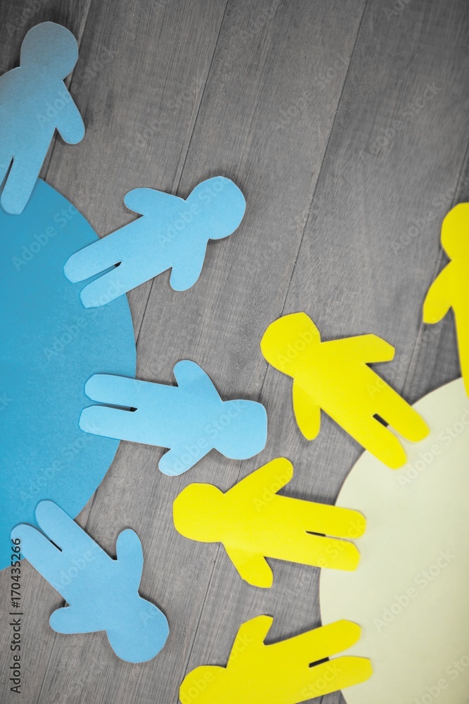 Obraz premium Blue and yellow paper cut out figures on wooden table