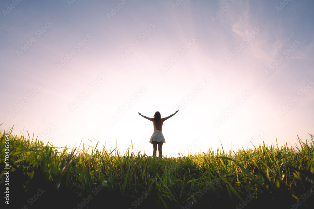 Free woman raising hands to golden sunset Free woman raising hands to golden sunset