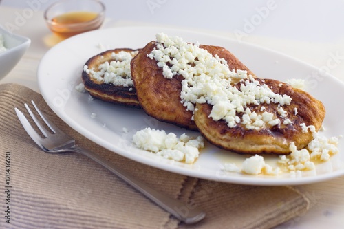 Homemade gluten free pancakes with cottage cheese and honey served on oval plate