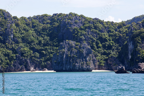 cruising among beautiful limestone rocks and secluded beaches in Ha Long bay, UNESCO world heritage site, Vietnam