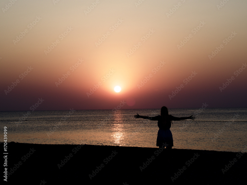 Silhouette von einer jungen Frau beim Sonnenaufgang 