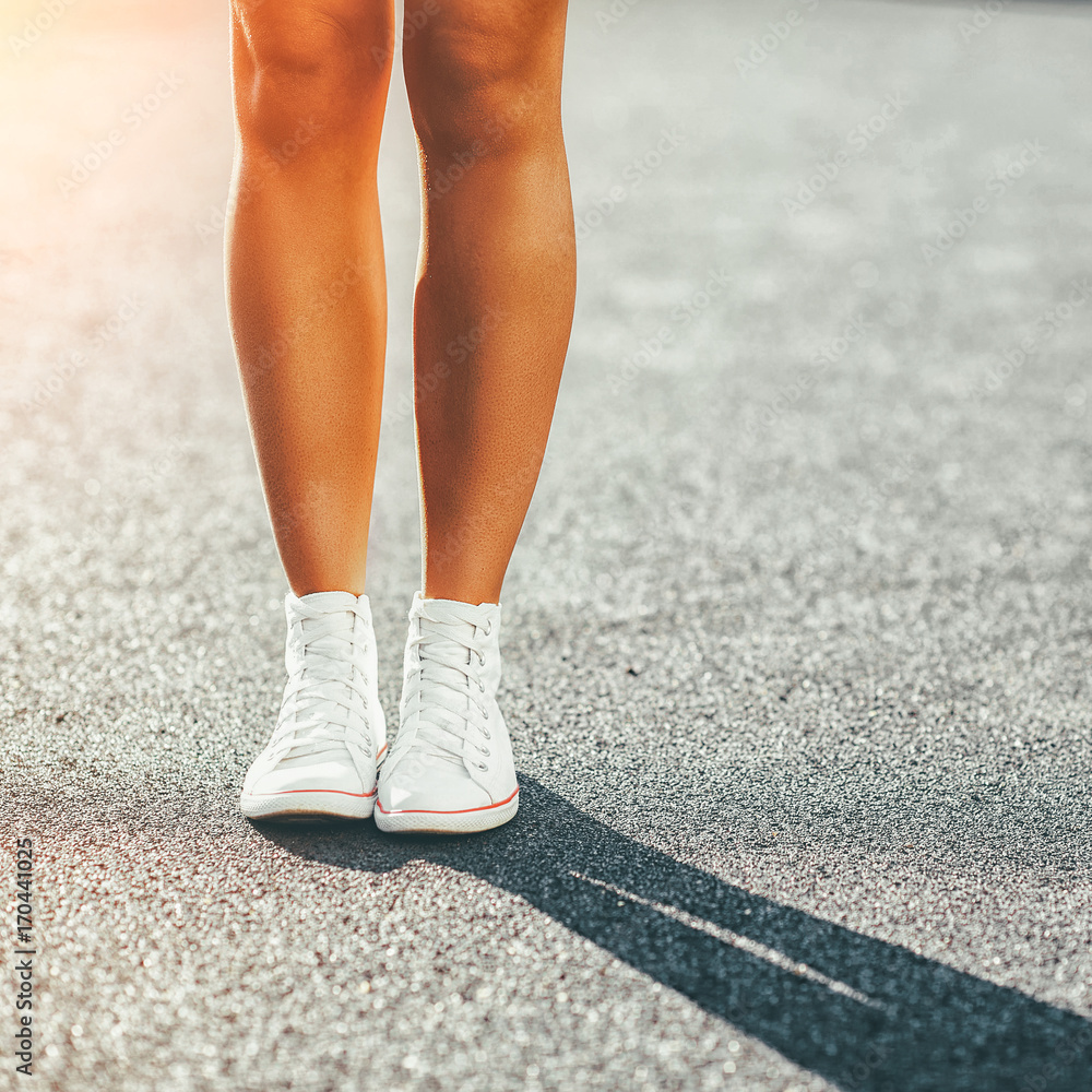 Female legs in sneakers - close up portrait Female legs in sneakers - close up portrait