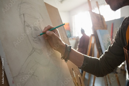 Cropped image of man sketching on canvas photo