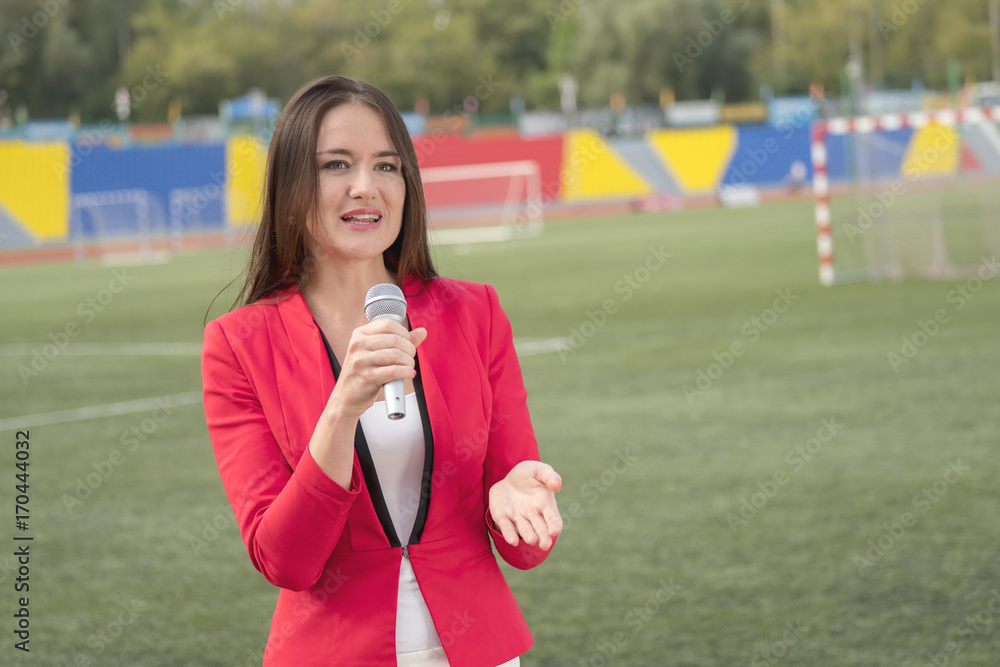 The journalist is reporting from the stadium for television The journalist is reporting from the stadium for television