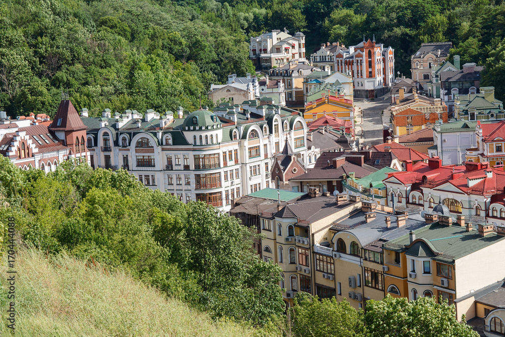 Fototapeta premium Multicolored houses surrounded by green trees. Kiev, Ukraine