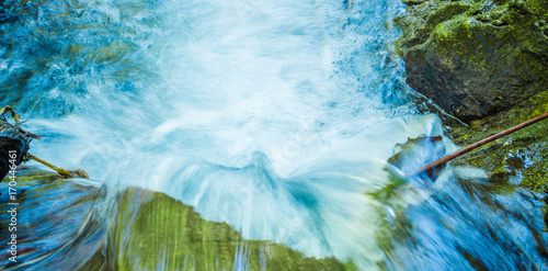 Beautiful river inside of a green forest with stones in river at Mindo