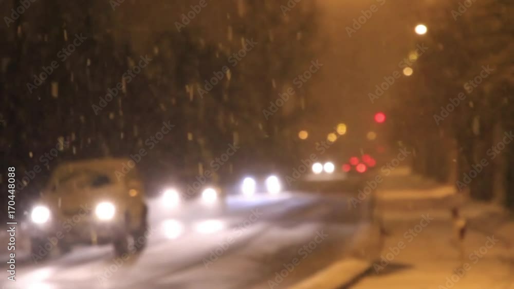 Nevando copiosamente en una calle de noche, con coches en movimiento que se acercan y alejan. Fuera de foco o desenfocado Nevando copiosamente en una calle de noche, con coches en movimiento que se acercan y alejan. Fuera de foco o desenfocado