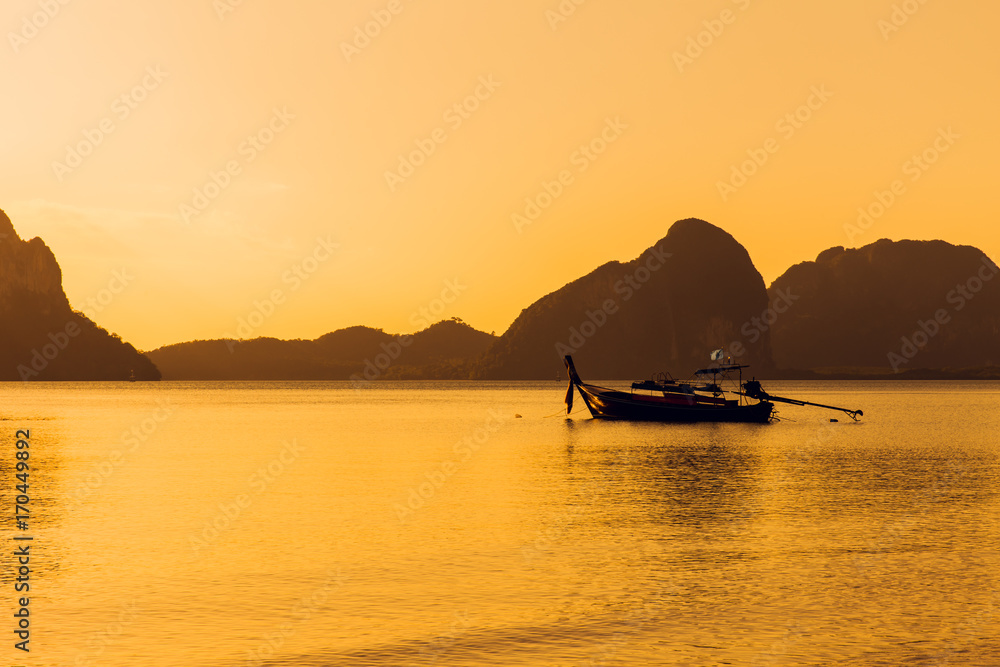 sunset sea calm ocean with silhouette of fishing boat and mountain landscape