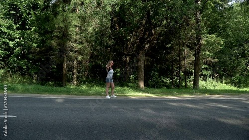 Wallpaper Mural Hitchhiking woman with backpack on road on fores background Torontodigital.ca
