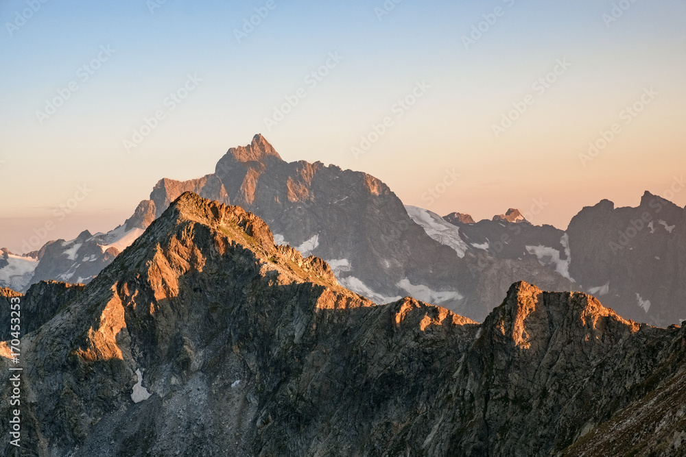 mountain peaks with snow at sunset, sunrise on sky background