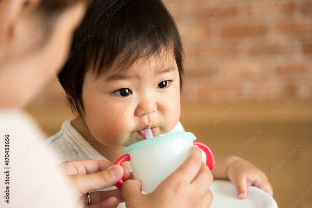 椅子に座って飲み物を飲む赤ちゃん 椅子に座って飲み物を飲む赤ちゃん