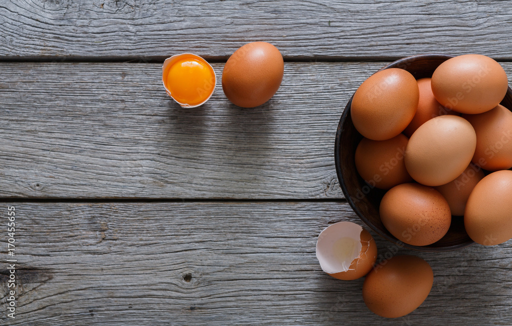Brown and white organic eggs in bowl on wood background Brown and white organic eggs in bowl on wood background