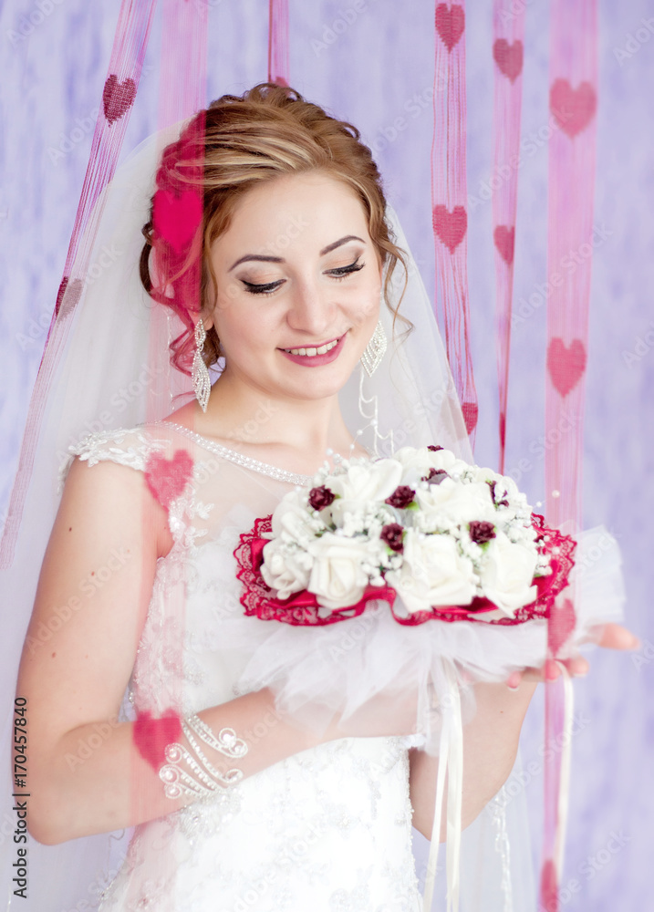 Beautiful and happy bride with bouquet in hands. Purple background with red hearts. Portrait of a gentle bride.