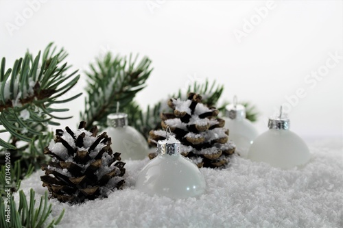 An Image of a Christmas deco with balls, snow,and tree photo