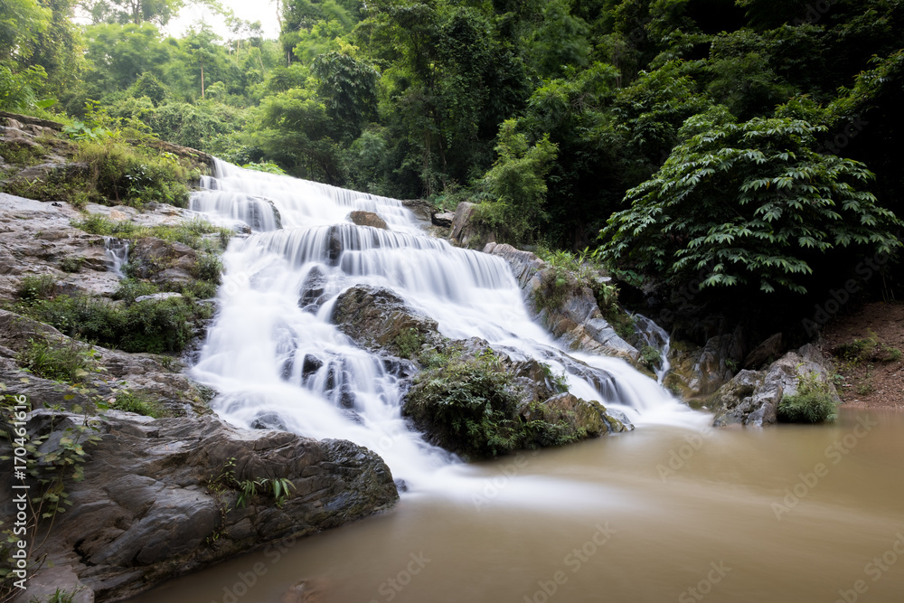 Fototapeta premium Smooth flow water from Mae Phun waterfalls in Laplae District, Uttaradit province of Thailand