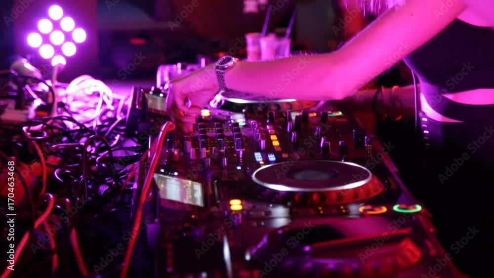 Ragazza che fa la dj su una consolle in discoteca