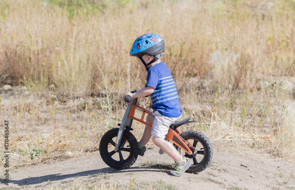Toddler on a Strider Bike at a Dirt Track Wearing Helmet Toddler on a Strider Bike at a Dirt Track Wearing Helmet