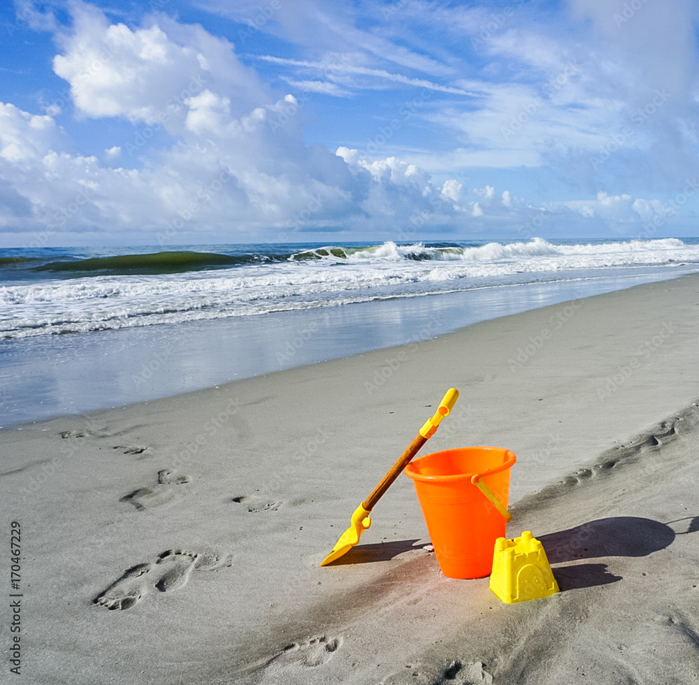A Shovel and Pail on the Beach in the Sand A Shovel and Pail on the Beach in the Sand