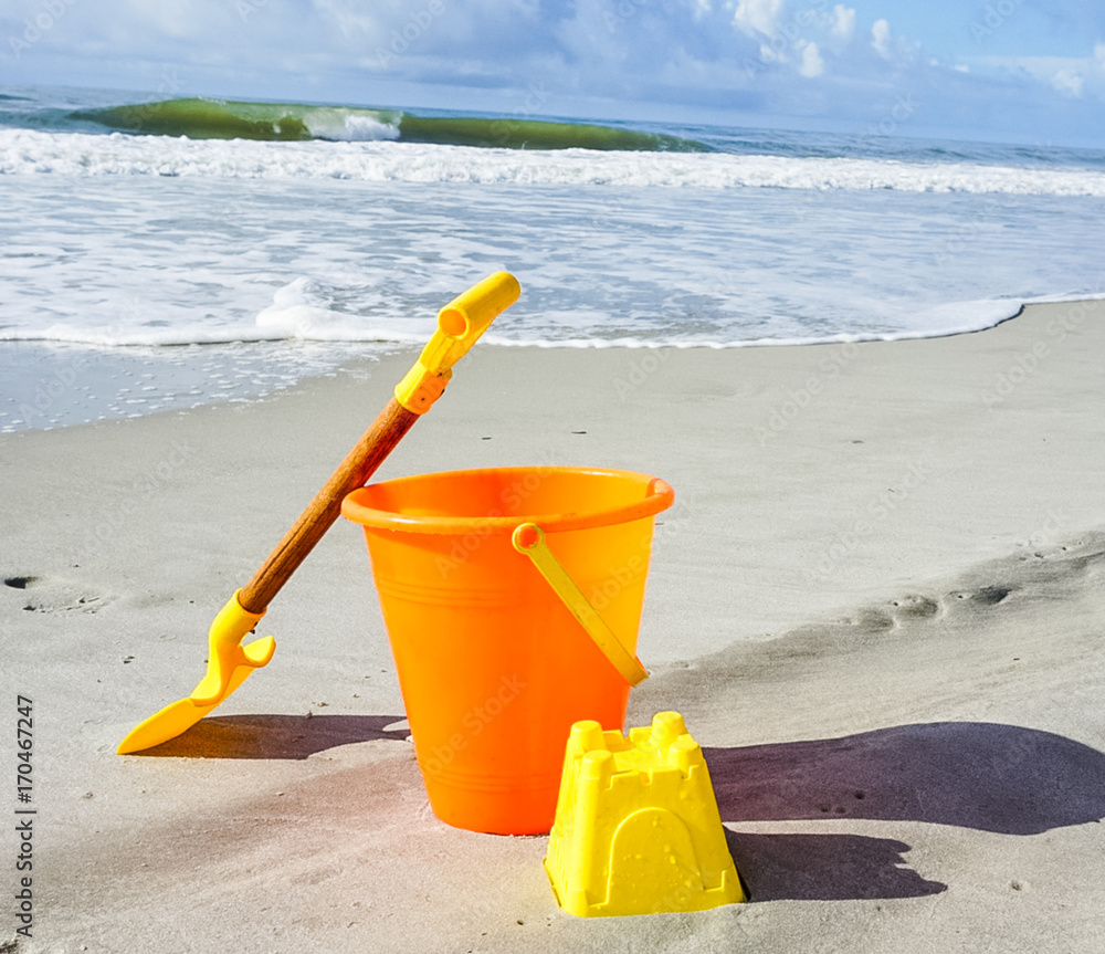 A Shovel and Pail on the Beach in the Sand A Shovel and Pail on the Beach in the Sand