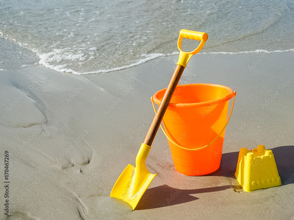 A Shovel and Pail on the Beach in the Sand A Shovel and Pail on the Beach in the Sand
