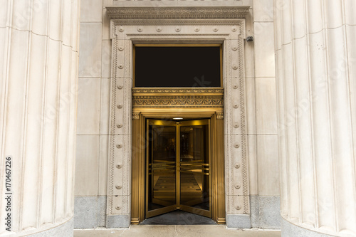 Golden revolving door with massive columns © Richard