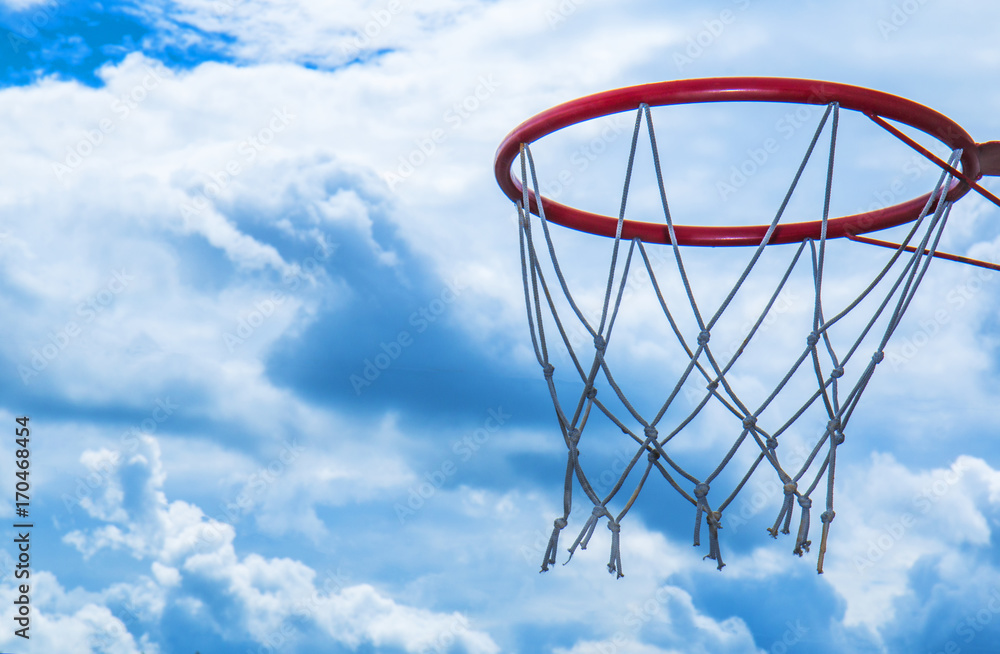 red basketball basket, ring, against a beautiful sky with snow-white clouds, symbolizes devotion to the sport