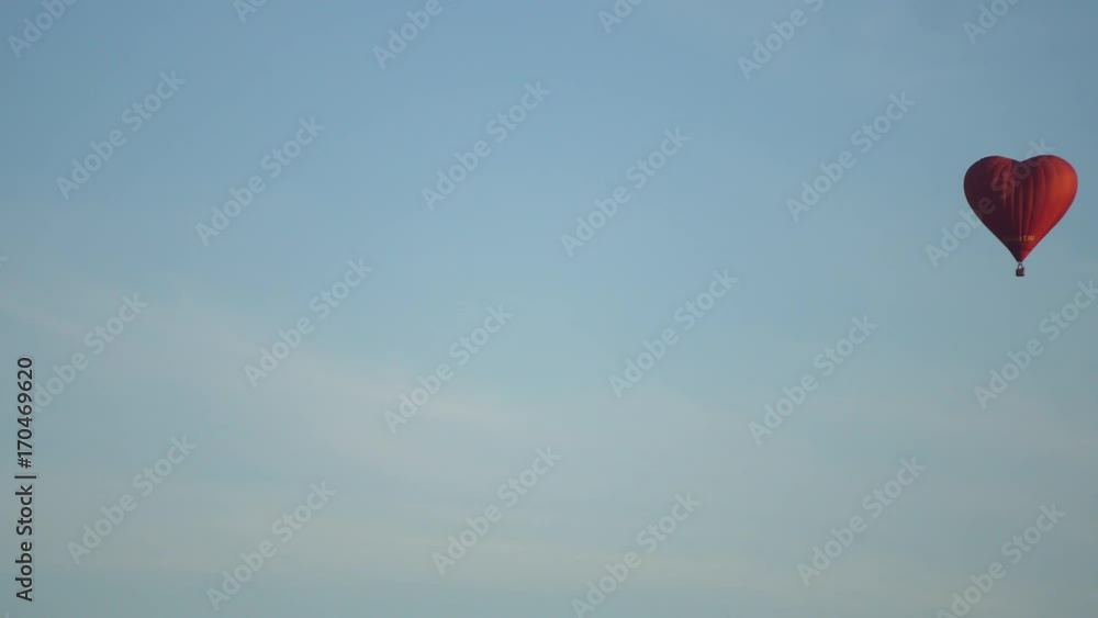 Hot air balloon shape of a heart in the blue sky. Aerostat, Airship. Red balloon.4k Hot air balloon shape of a heart in the blue sky. Aerostat, Airship. Red balloon.4k